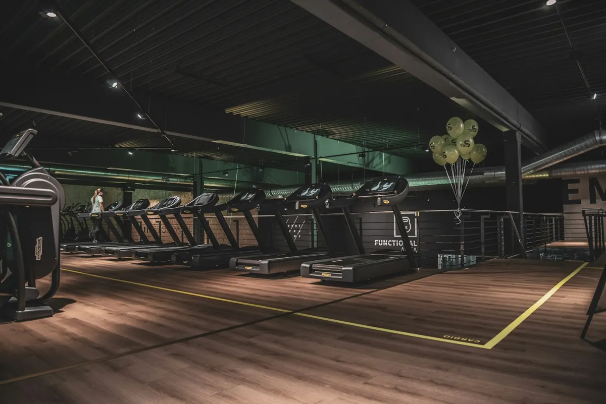 Área de treino com piso de madeira e equipamentos